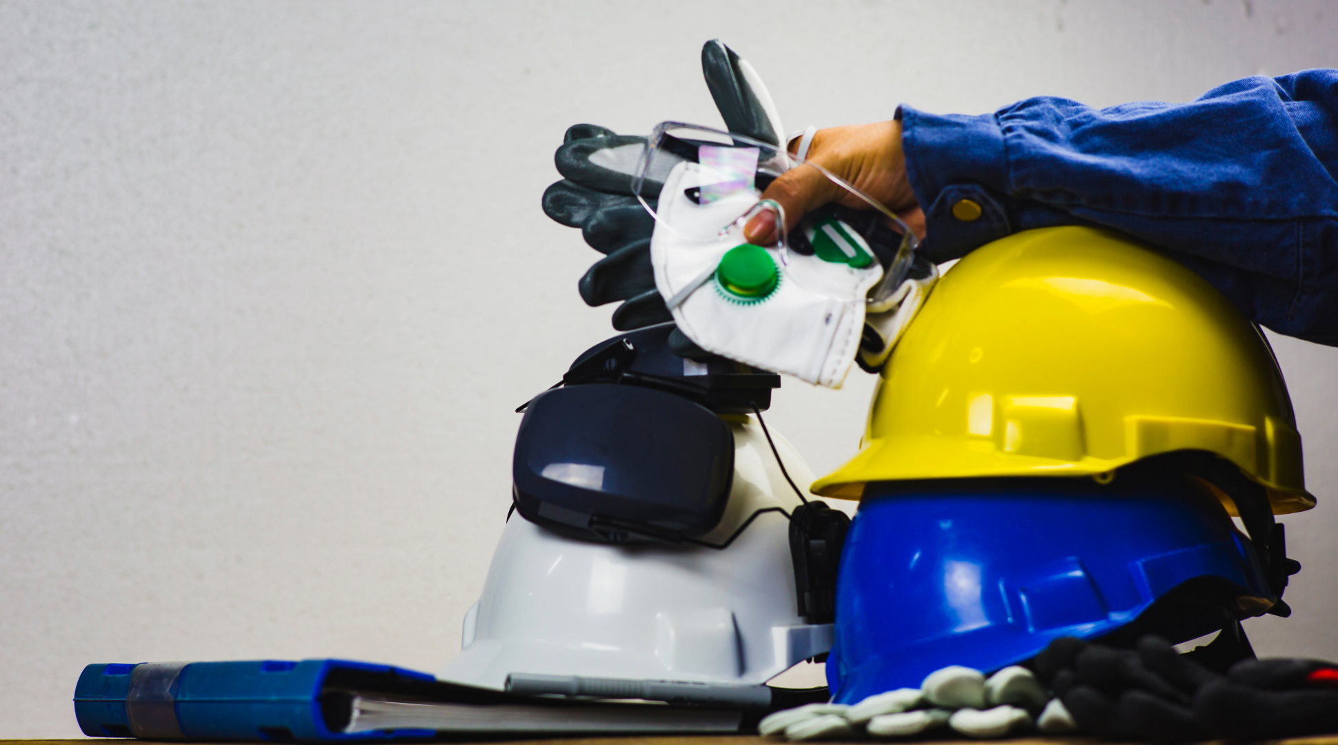 Man holding up different PPE items - industries that use ppe - ppe clothing