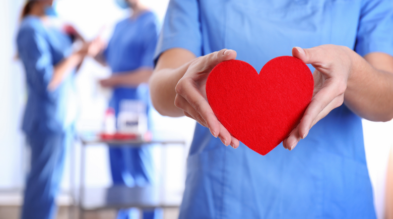 Nurse holding red paper heart - medical scrubs - international nurses day
