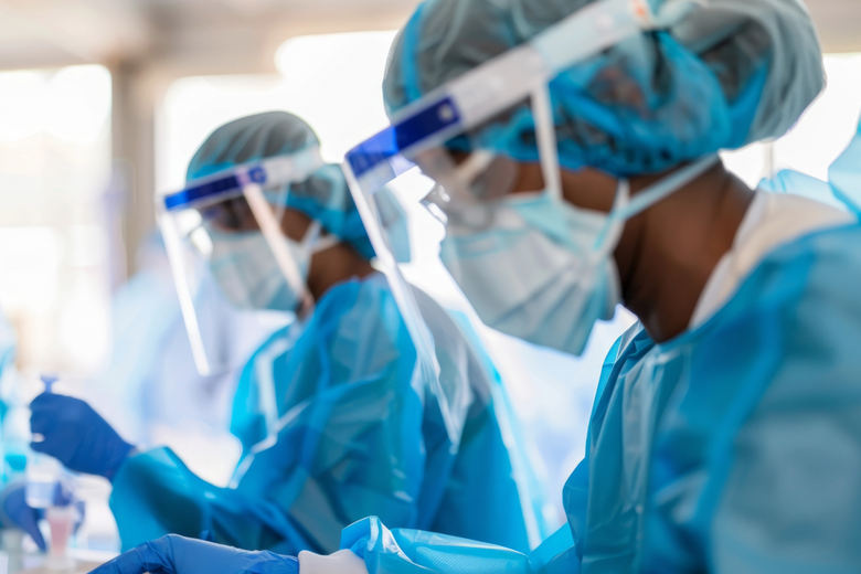 2 Women working in a lab wearing PPE clothing